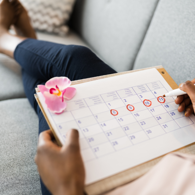 Frau notiert in ihrem Zykluskalender ihre Periode